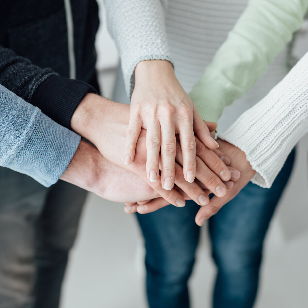 Young people stacking hands together: teamwork, collaboration and support concept